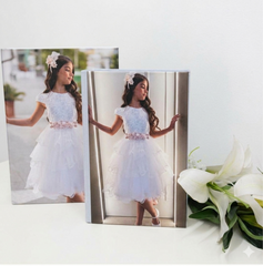 Dettaglio del Kit Mary: album fotografico con copertina in tela canvas personalizzata con il ritratto di una bambina, chiuso lateralmente da un elegante nastrino di raso bianco legato a fiocco.