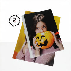Dettaglio del Kit Mary: album fotografico con copertina in tela canvas personalizzata con il ritratto di una bambina, chiuso lateralmente da un elegante nastrino di raso bianco legato a fiocco.